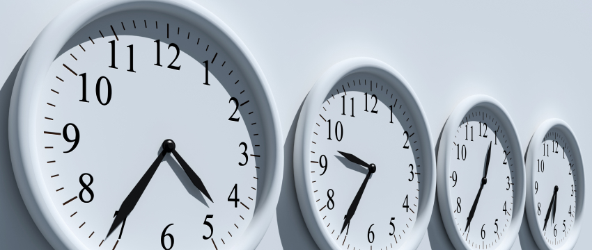 Four aligned clocks indicating different times, used for forex trading time analysis and financial decision-making.