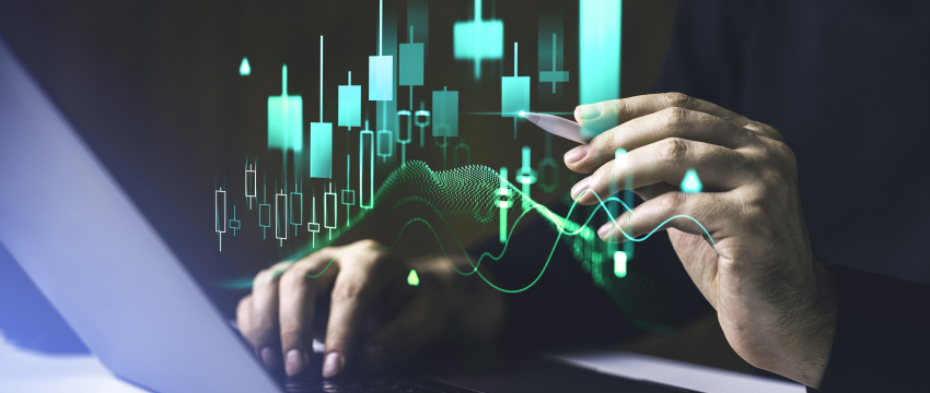 A person analyzing forex charts on a laptop, focused on the displayed graph.